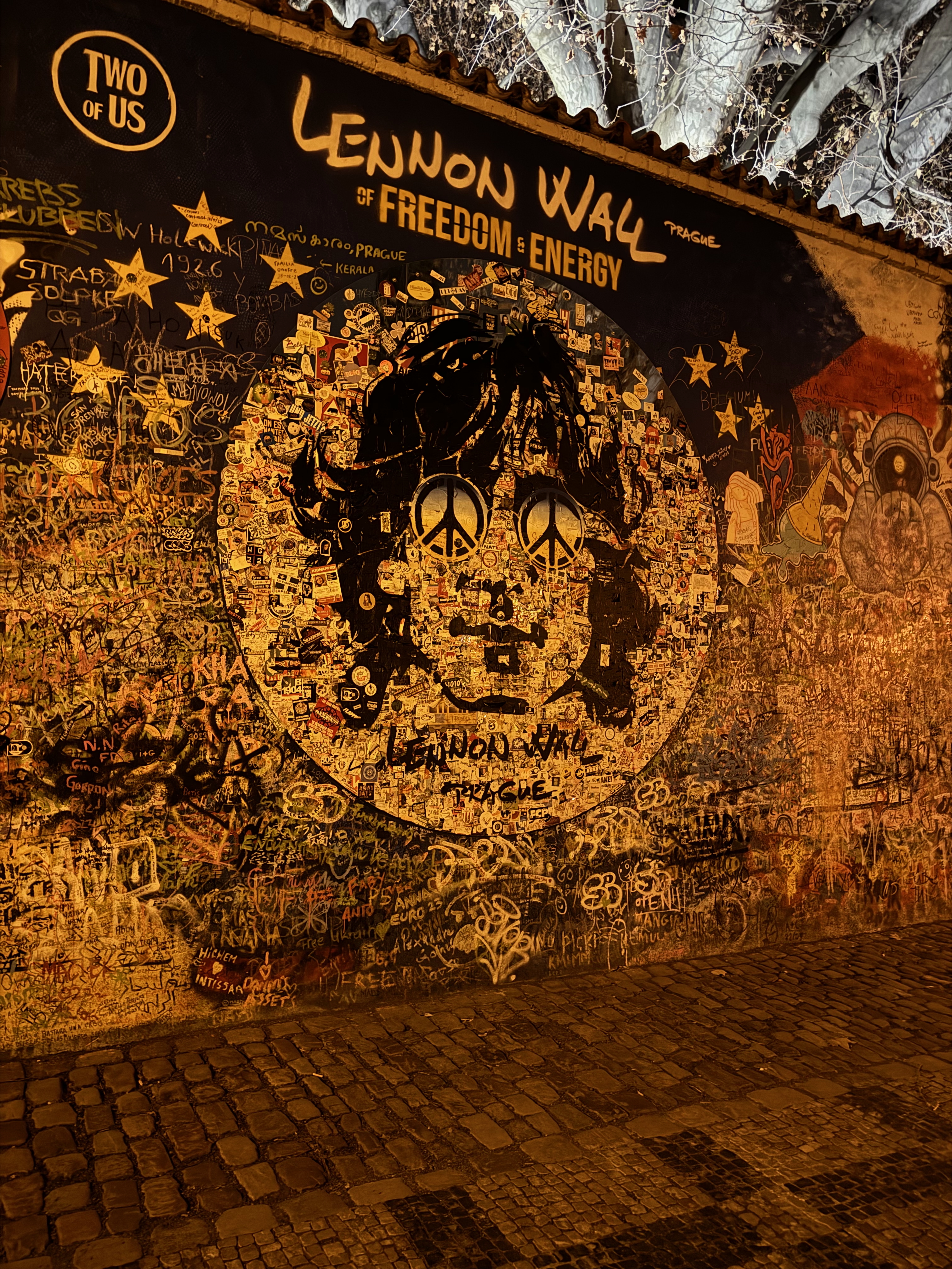 The Lennon Wall lit at night in Prague
