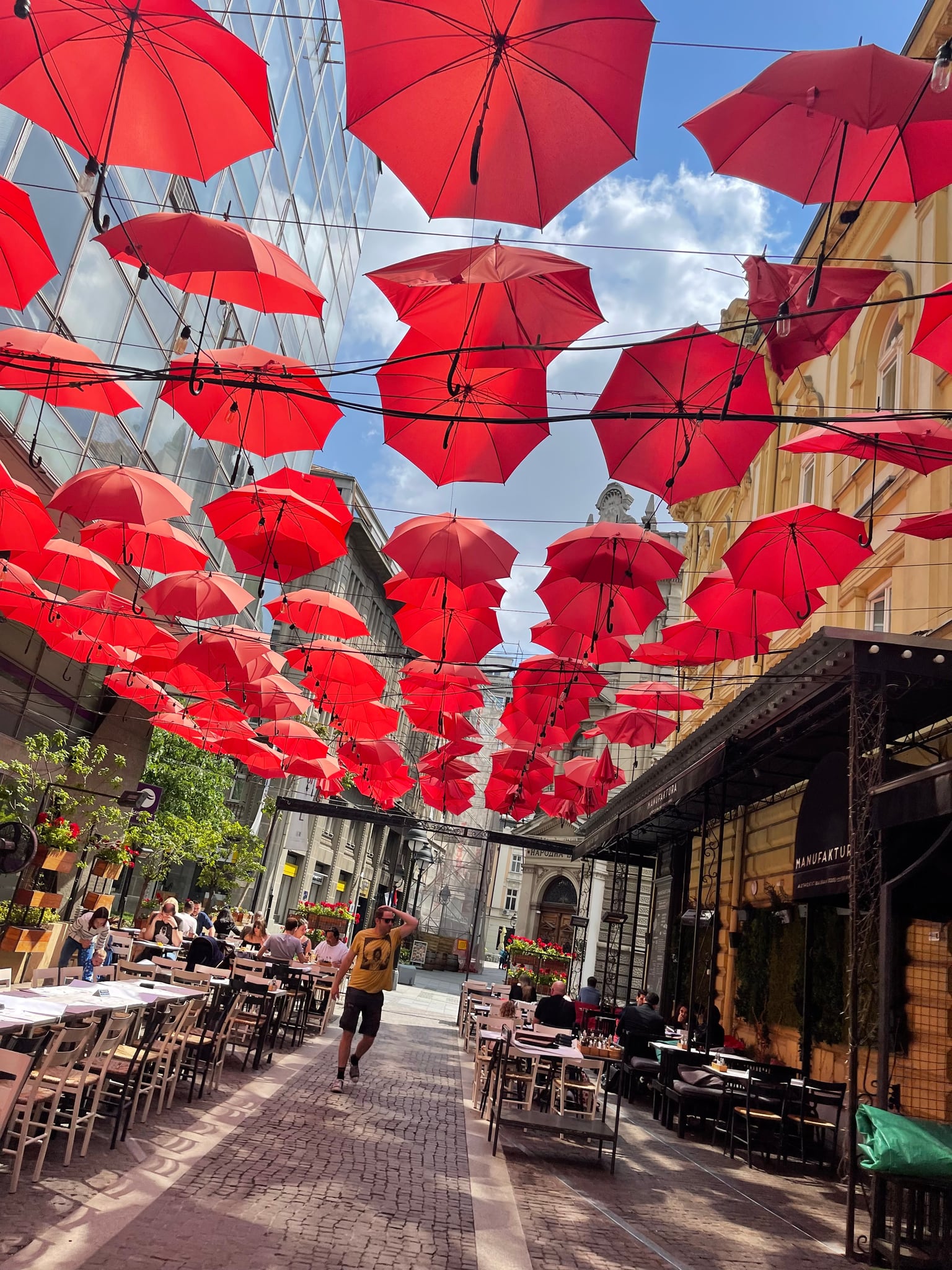 Red umbrellas above a restaurant street in old Belgrade