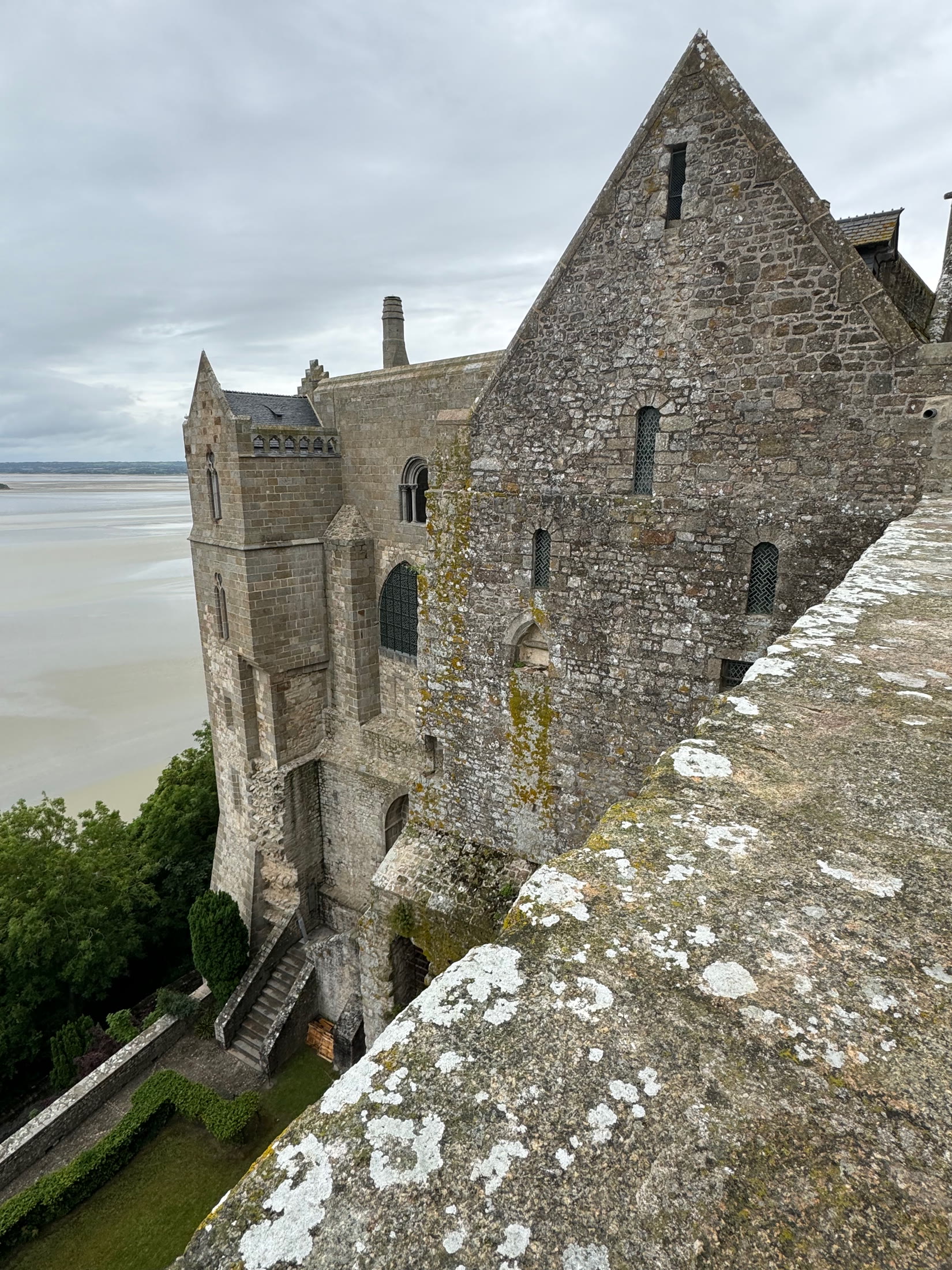Stone walls of Mont-Saint-Michel Abbey above the bay