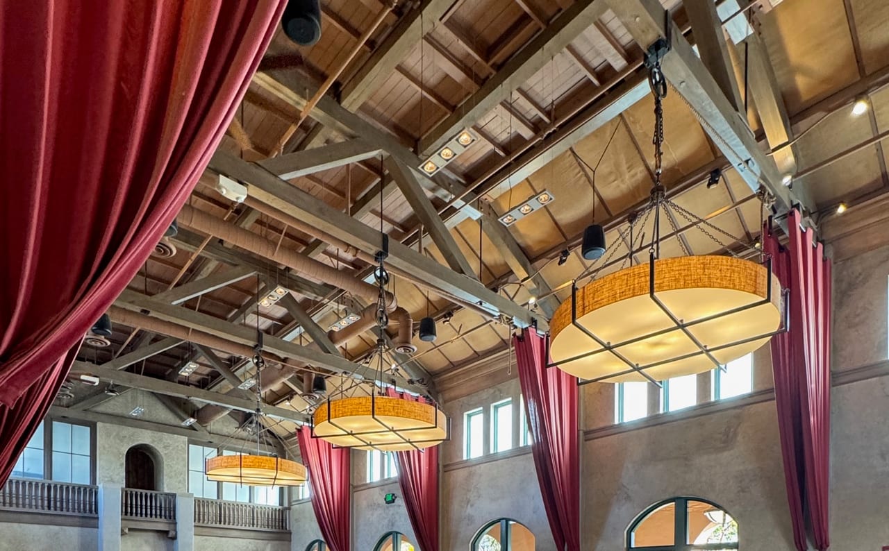 Wood trusses, red curtains, and hanging lights inside Stone Brewing Liberty Station