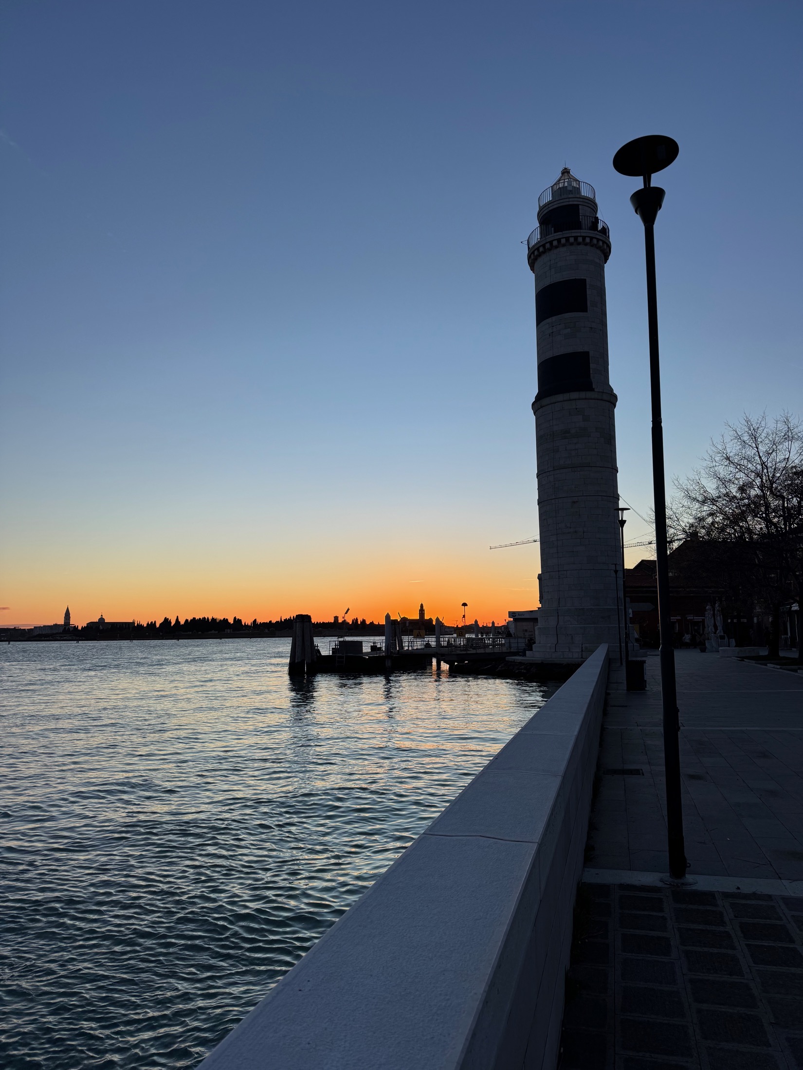 The Murano lighthouse at sunset across the Venetian lagoon