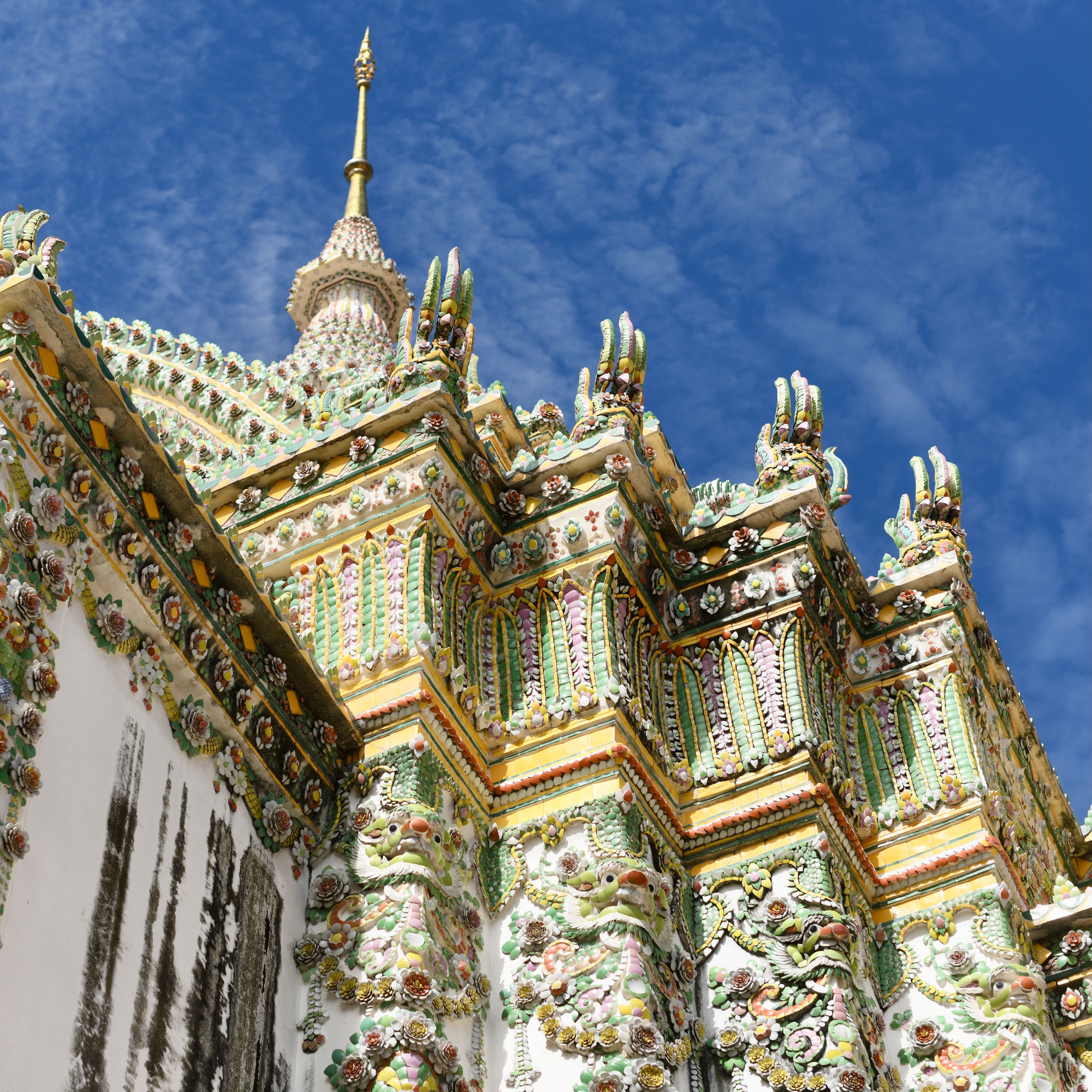 Porcelain detail on Wat Arun under a blue Bangkok sky